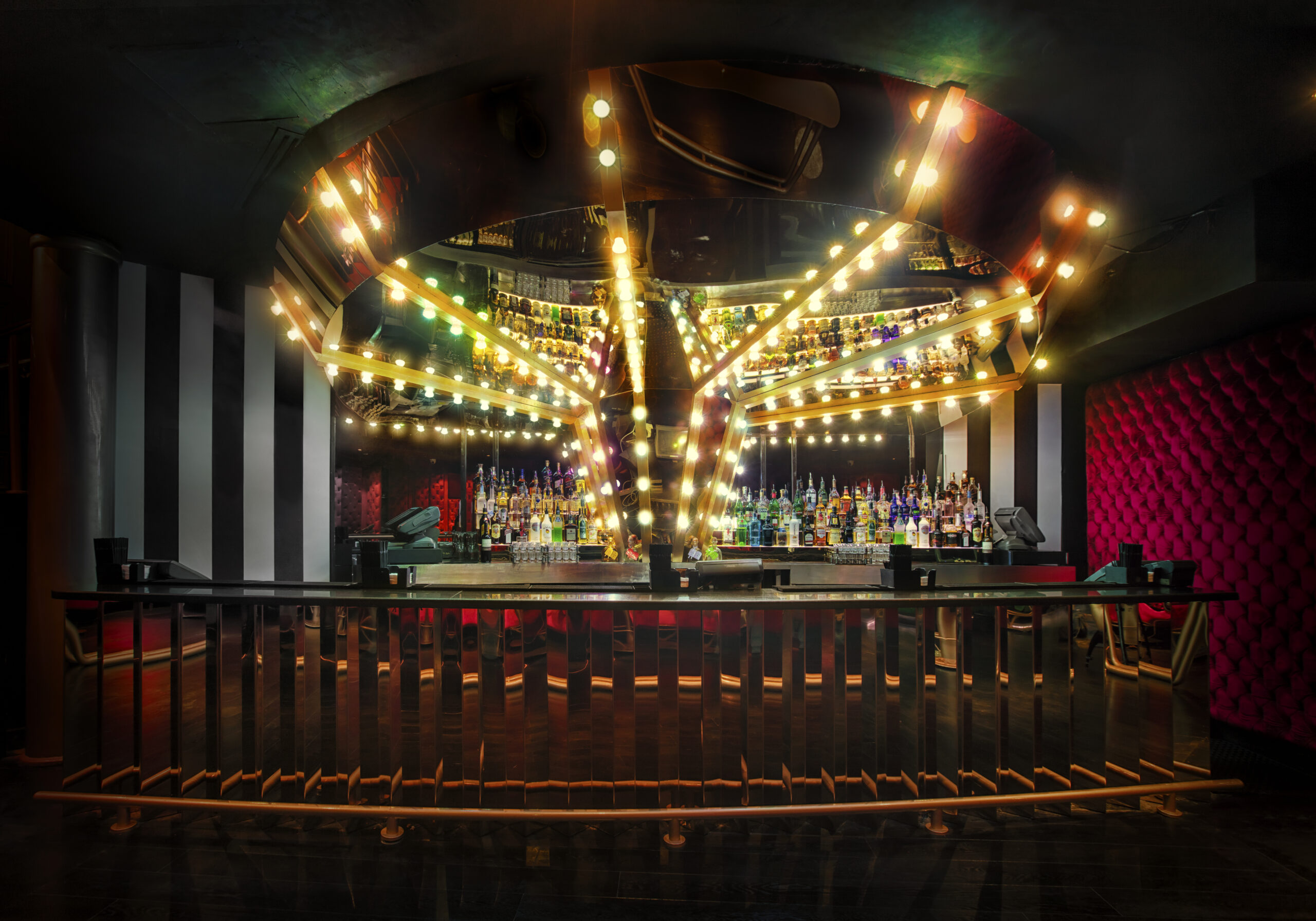 Carousel-style bar with star-shaped illuminated structure and bottles displayed under warm lights