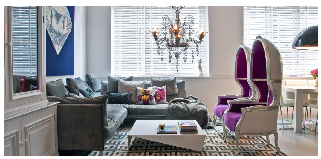 Eclectic living room with grey sofa, purple high-back chairs, modern coffee table and chandelier in Soho