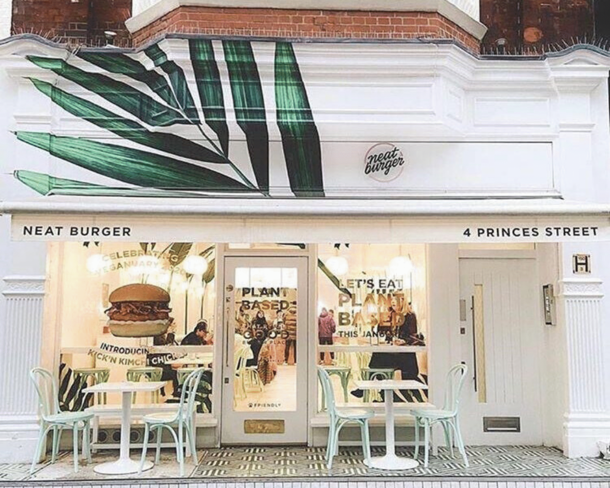 Neat Burger restaurant facade on Princes Street with large green leaf mural and outdoor tables